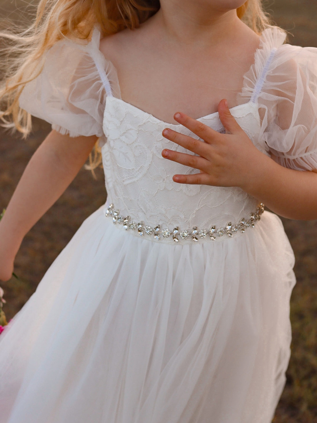 A girl wearing a blue dress with a sparkling silver sash