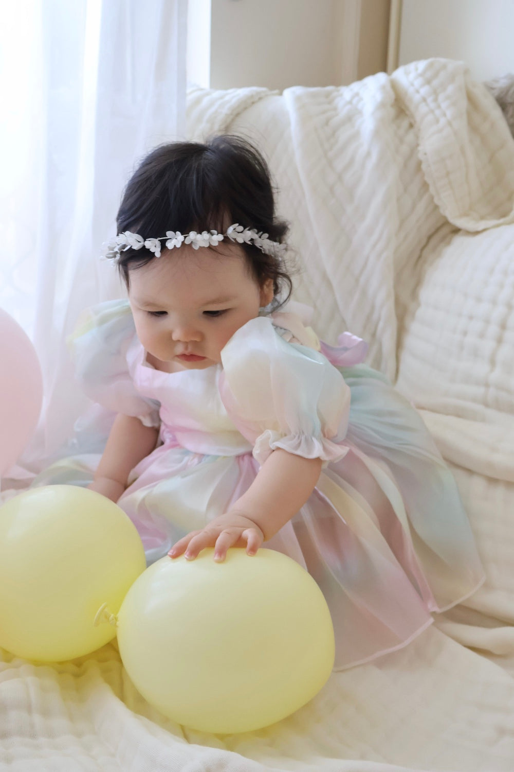 Anastasia Baby Rainbow RomperBaby girl in shimmery rainbow organza romper with puff sleeves, smiling at her first birthday