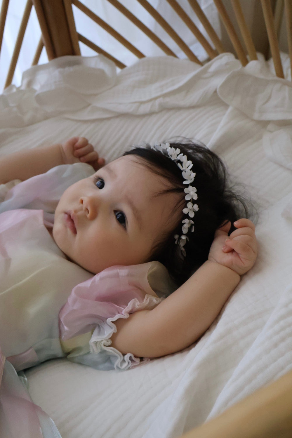 Baby laying in shimmery rainbow romper, snap closures secure and comfy for play