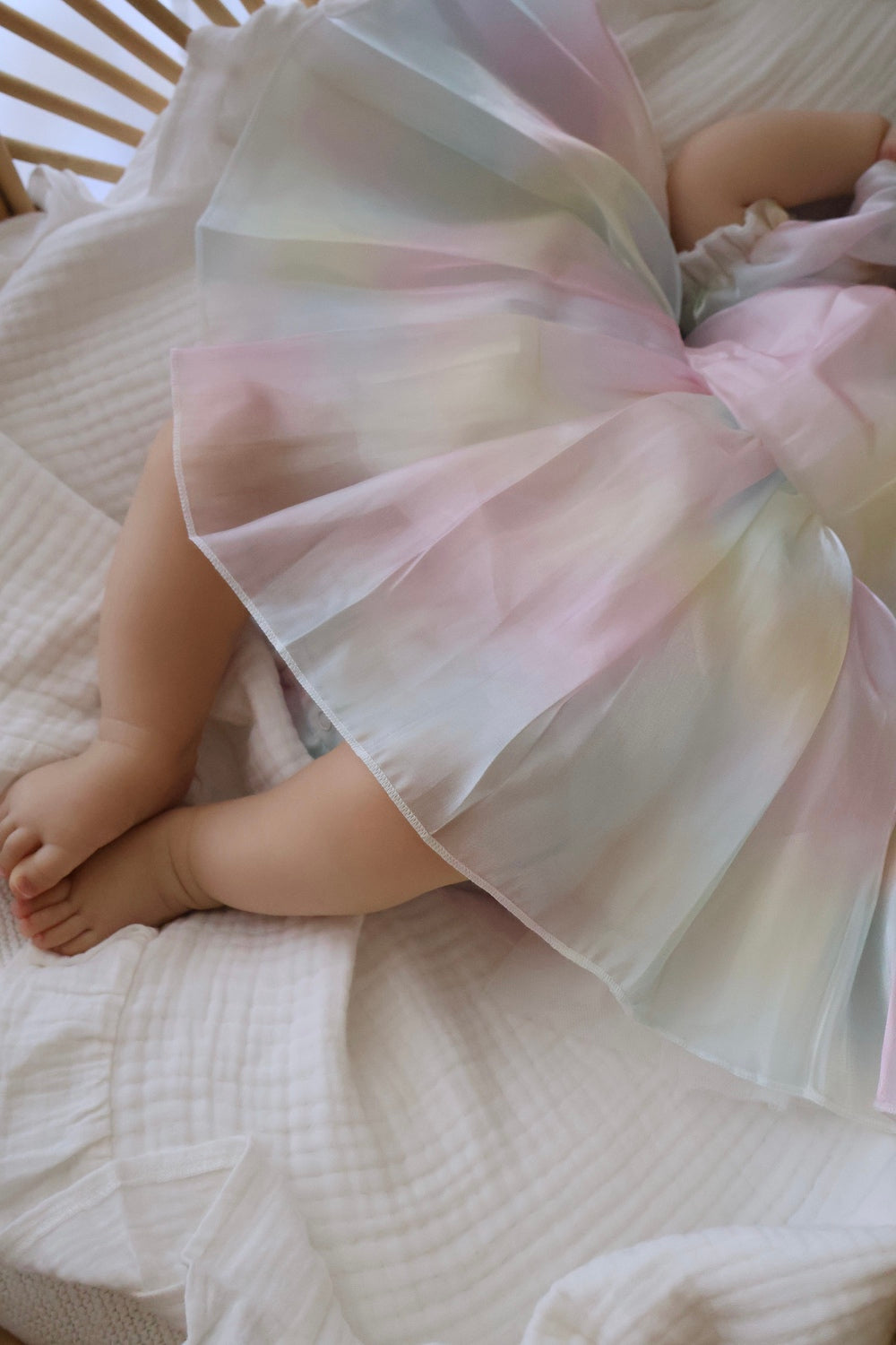 Rainbow organza baby romper styled with headband, ideal for first birthday photos