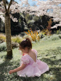 Girl pink baby romper dress showing large bow and soft V-back design Australia