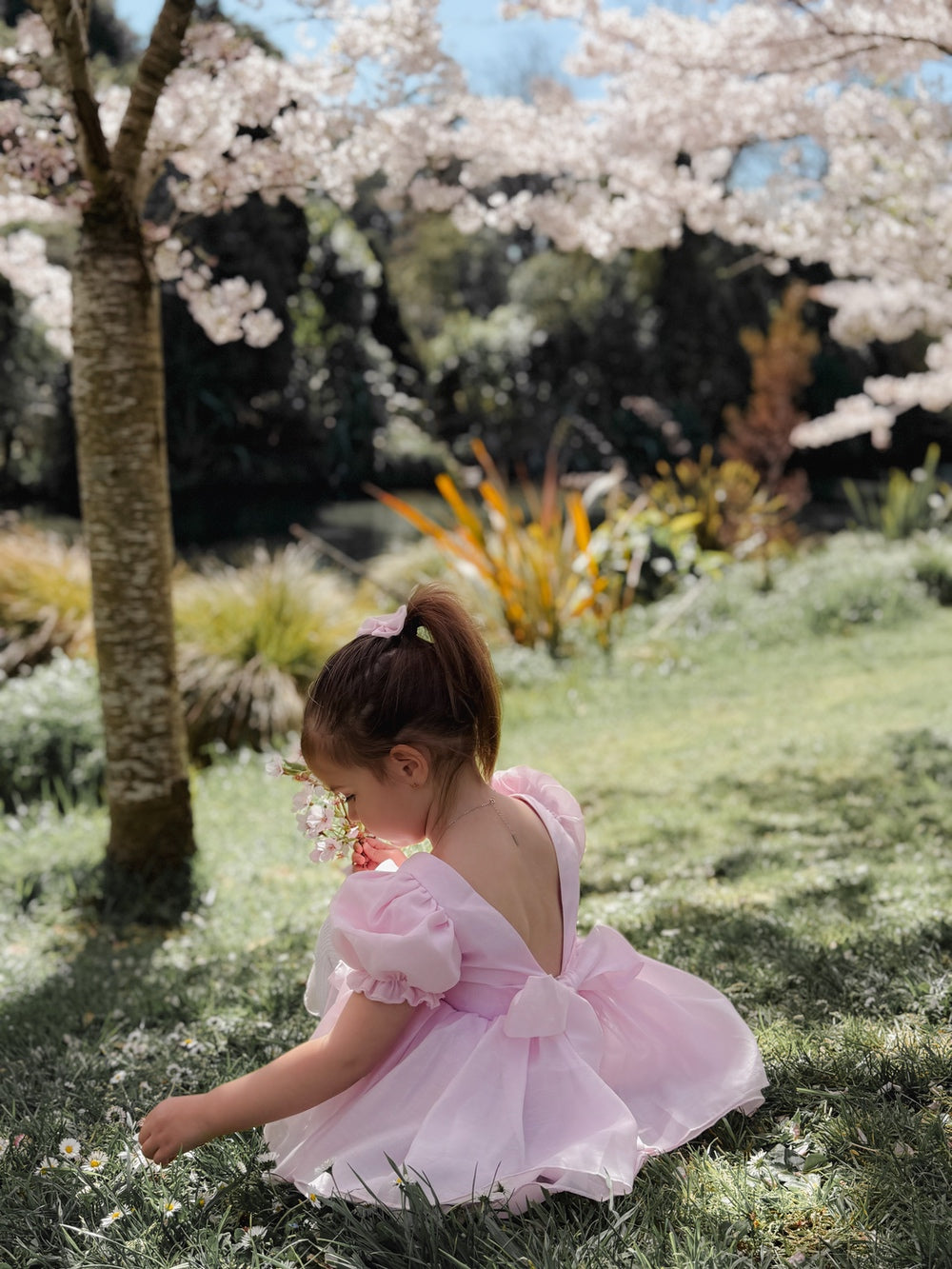 Girl pink baby romper dress showing large bow and soft V-back design Australia