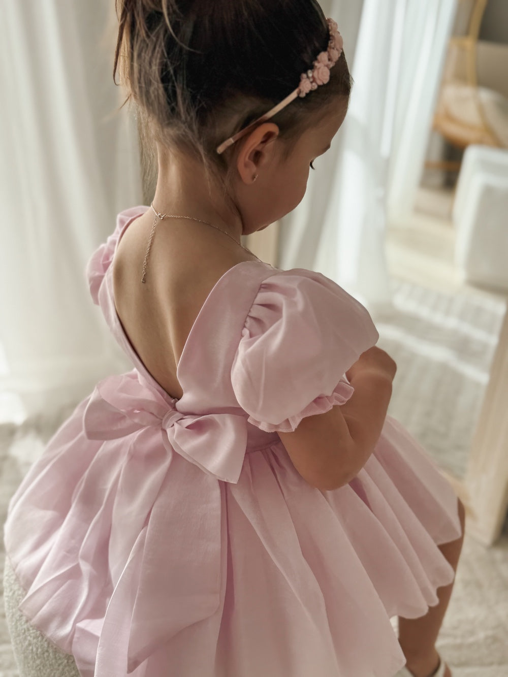 Back view of pink puff sleeve girls dress with V-back neckline
