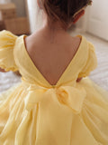 Baby sitting in Arabella yellow romper