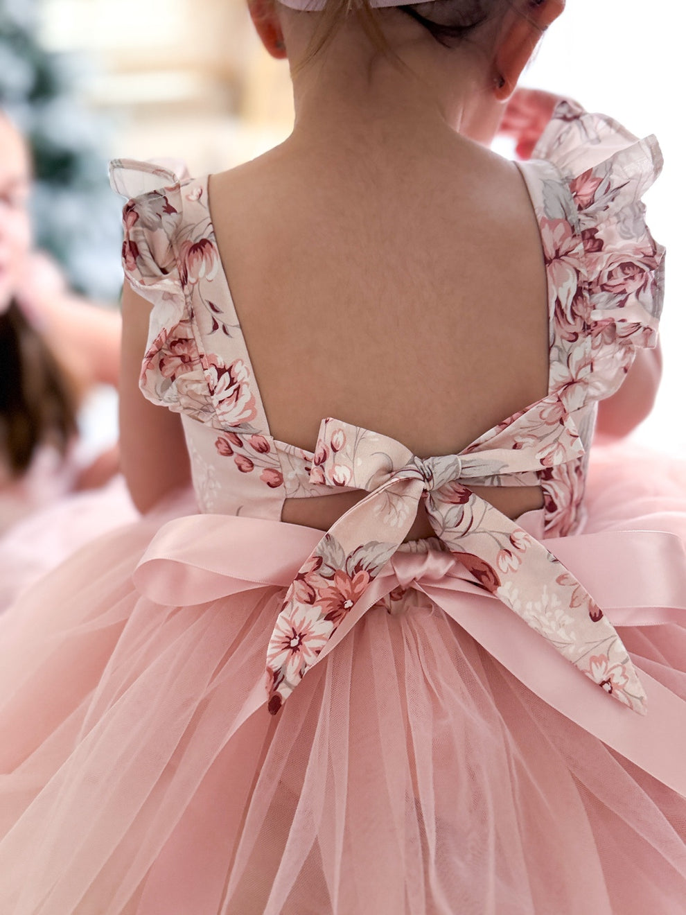 Back view showing elegant tie-up bow and soft flowing tulle skirt