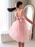 Tween girl twirling in dusty pink tulle party dress for wedding or birthday