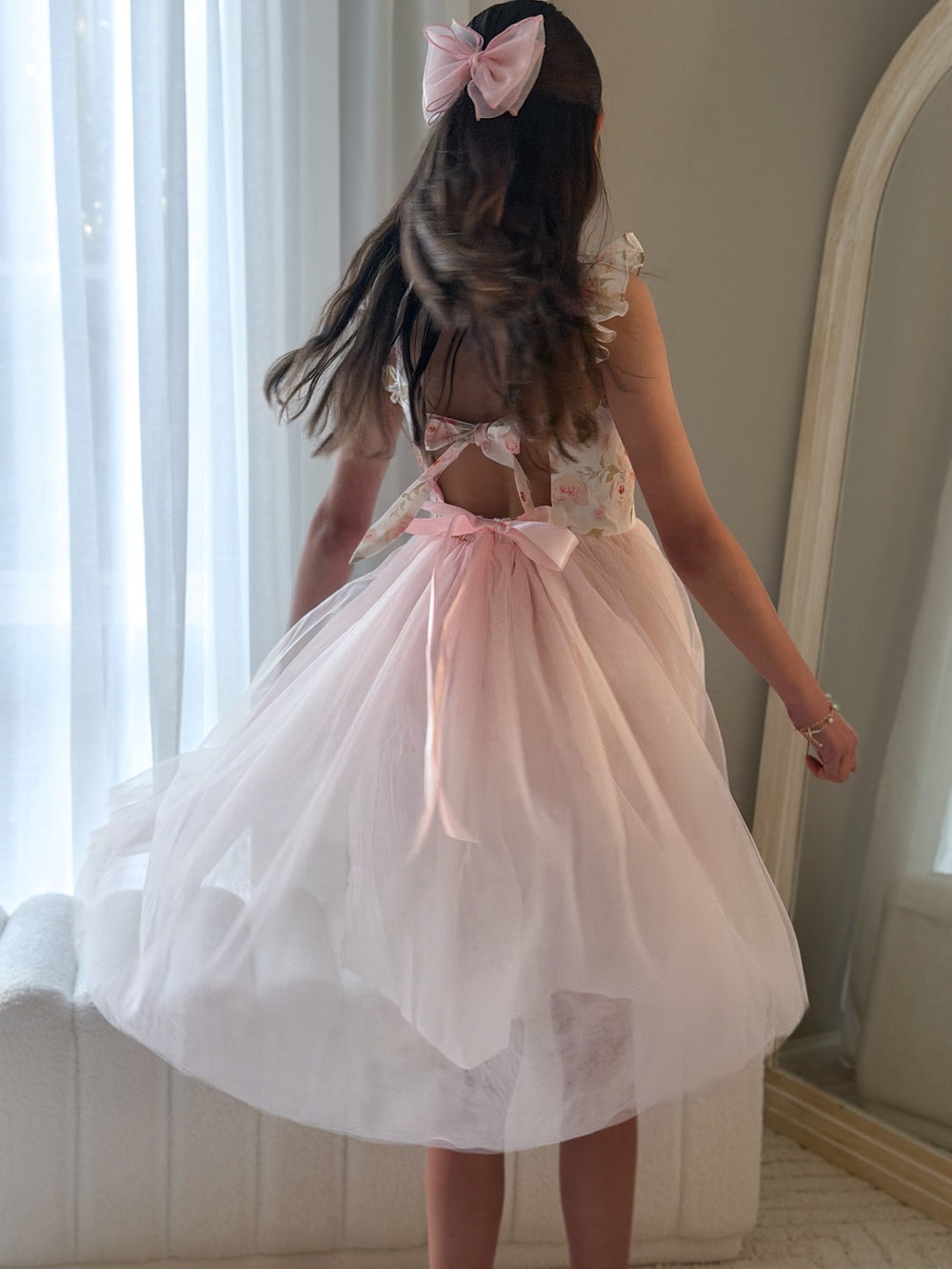 Flower girl wearing pink Audrey Rose dress with bow and layered tulle
