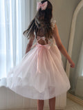 Flower girl wearing pink Audrey Rose dress with bow and layered tulle