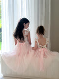 Two sisters wearing matching pink floral and tulle dresses for wedding day