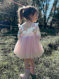 Close-up of white floral bodice with dusty pink flowers and ruffle shoulders