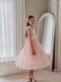Girl twirling in dusty pink tulle dress at a wedding celebration