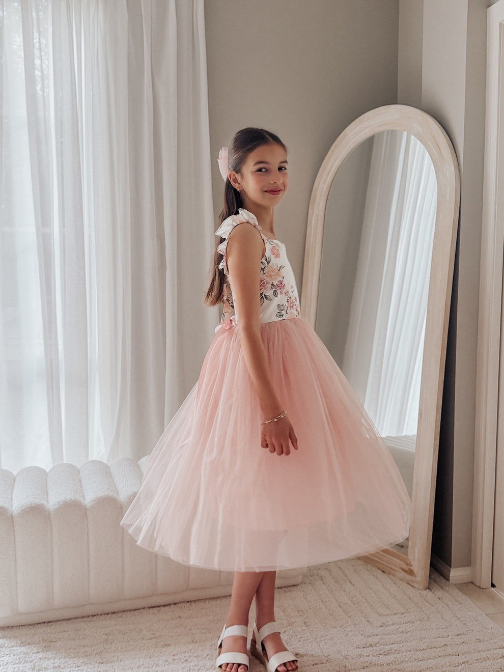 Girl twirling in dusty pink tulle dress at a wedding celebration
