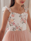 Flower girl posing in white and dusty pink tulle dress outdoors