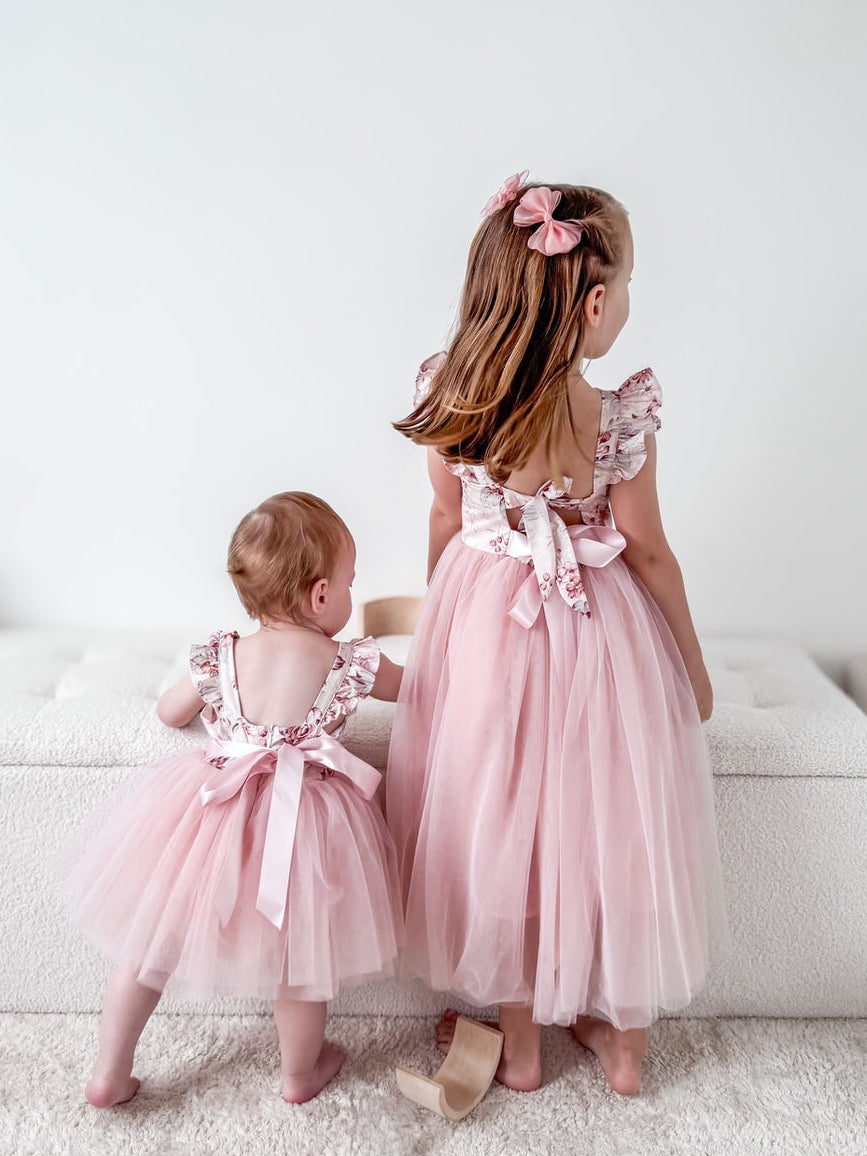 Matching sister outfits featuring baby in nectar floral romper and big sister in Audrey Rose Dress