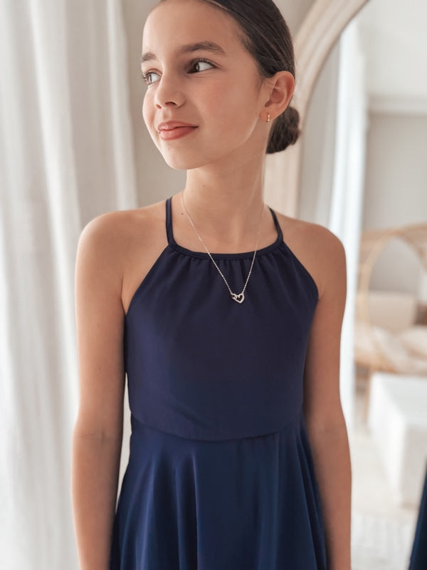 Tween girl wearing elegant navy chiffon dress for graduation day