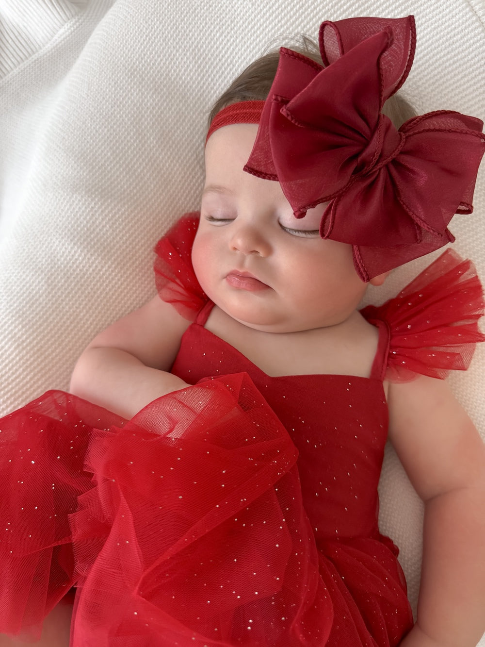 Close-up of glitter tulle skirt on red Christmas baby dress