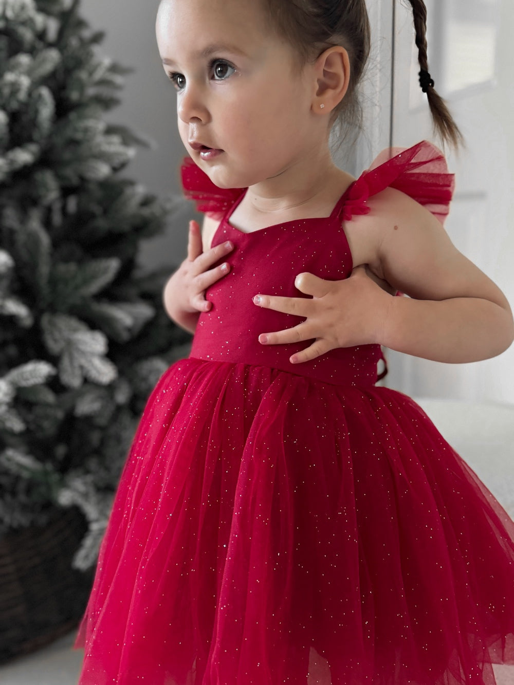Young girl in red sparkle tulle Christmas dress with flutter sleeves