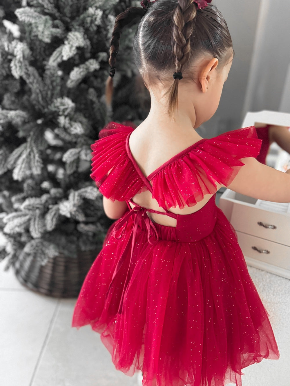 Girls’ holiday dress showing bow-tie back and shimmering tulle layers.