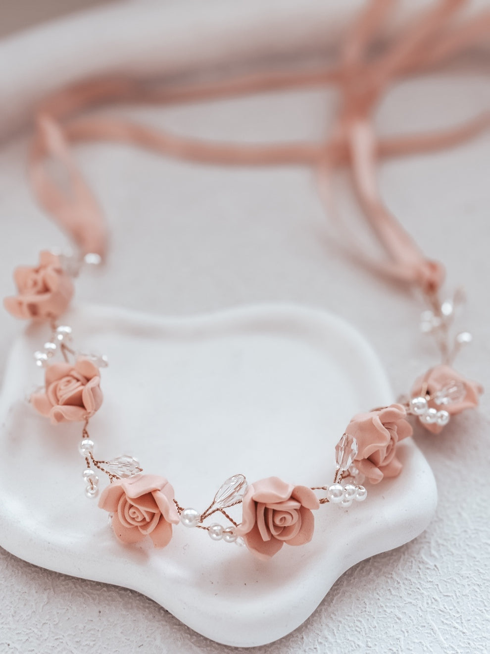 Flat lay of Blush Meadow Girls Headpiece – porcelain flowers, pearls, and clear diamantes