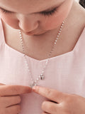 Detail shot of butterfly charms on girls silver necklace