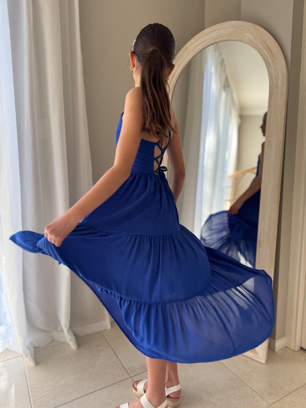 Clara blue dress styled from the side with full tiered movement