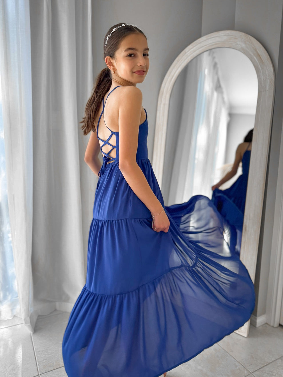 Sapphire blue chiffon dress spinning mid-twirl with soft flowing skirt