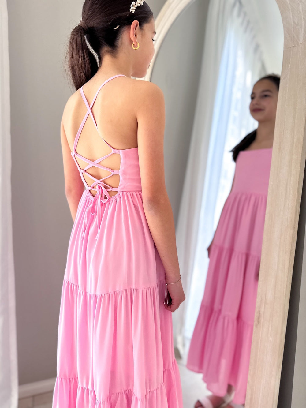 Tween in a pink occasion dress with relaxed fit and layered maxi design