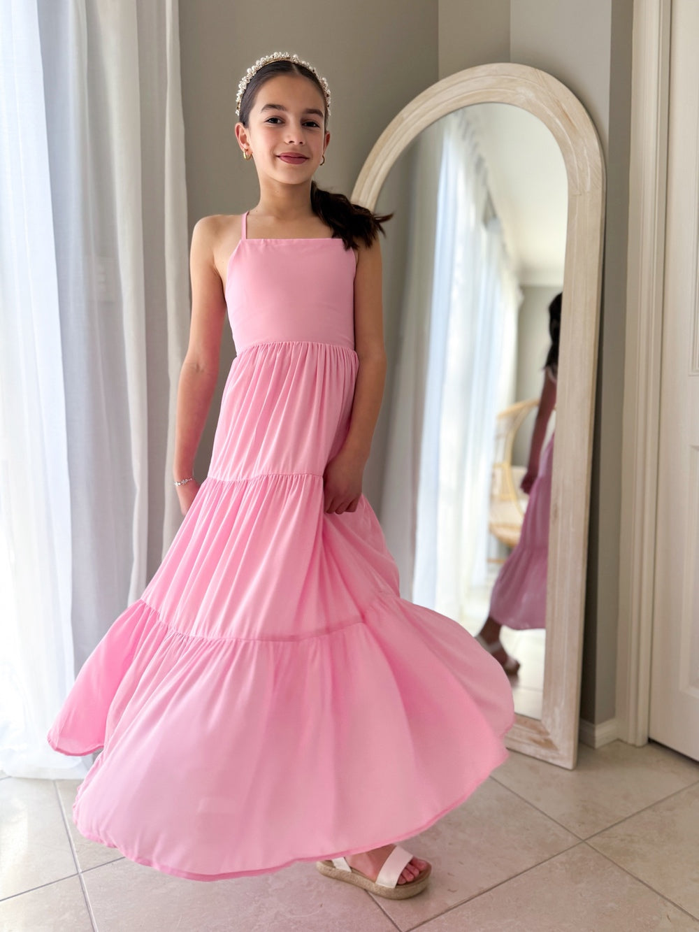 Flowy party dress for girls in pink chiffon caught mid-twirl