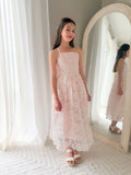 Girl standing in Clarissa Girls Light Pink Dress – flowing skirt and embroidered floral texture