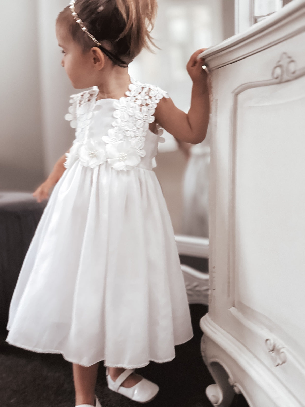 Front view of white flower girl dress with lace bodice and pearl flower details