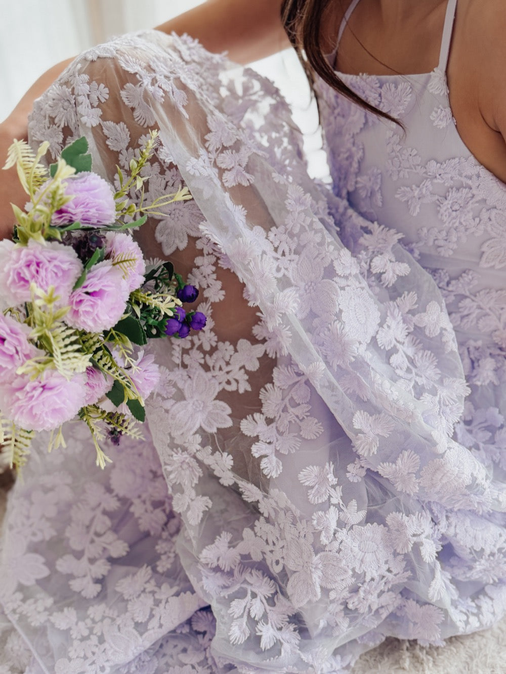 Clarissa lilac flower girl dress, close-up of the 3D floral tulle skirt with a purple bouquet.