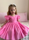 Girls vibrant hot pink special occasion dress with soft sheen fabric and bow detail