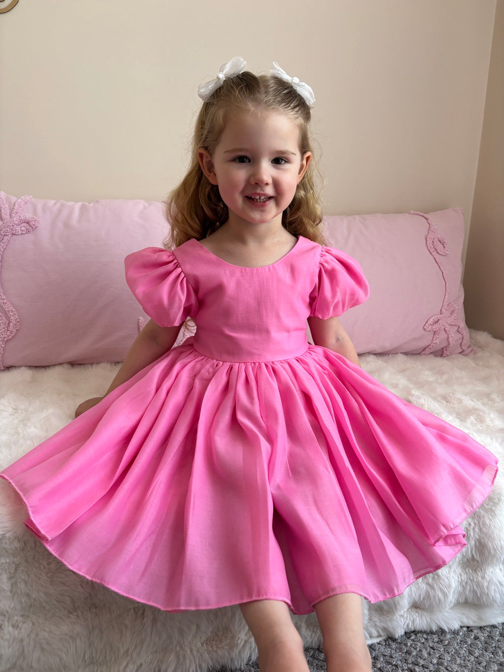 Girls hot pink dress with puff sleeves and statement bow – Delia below-knee party dress