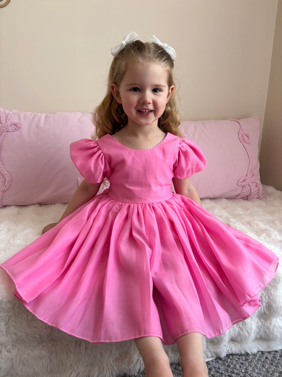 Girls hot pink dress with puff sleeves and statement bow – Delia below-knee party dress