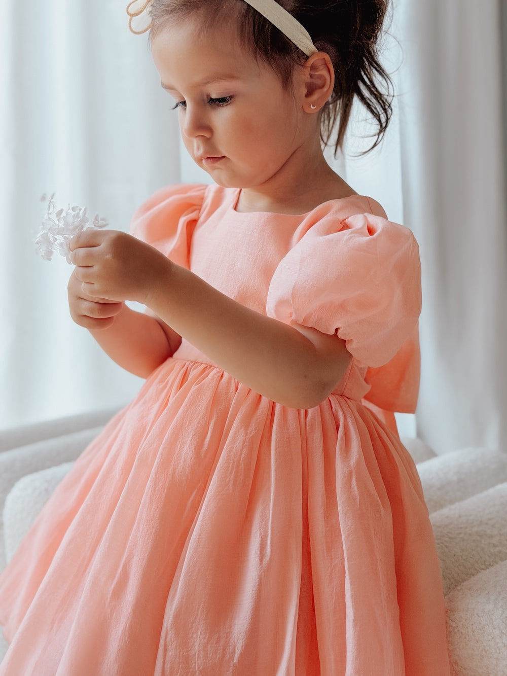 Girls peach formal dress with shimmering fabric and tied bow at the back.