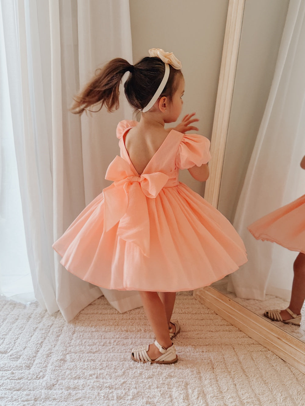 Delia Girls Peach Dress featuring puff sleeves and a below-the-knee peach skirt.