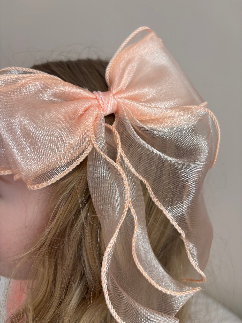 Curly Girls Peach Bow clipped into ponytail hairstyle