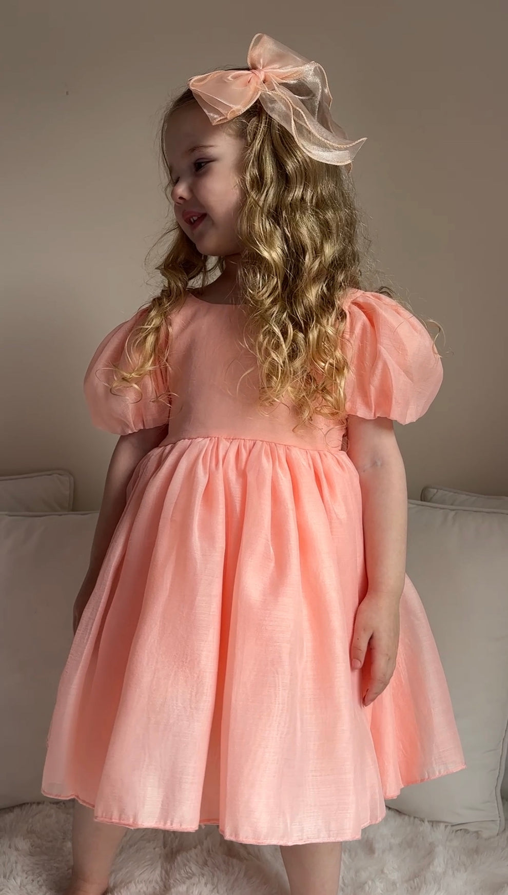 Close-up of peach V-back bow on Delia Girls Dress — perfect wedding and event dress