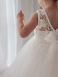 Back view of girls white communion dress showing V-back and bow