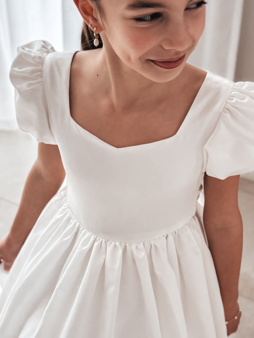 Close-up of sweetheart neckline and satin bodice with delicate puffed sleeves