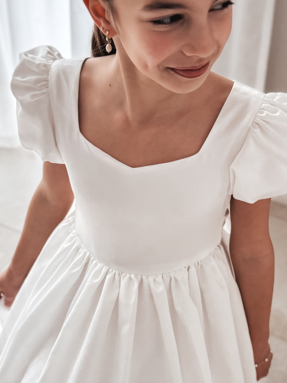 Close-up of sweetheart neckline and satin bodice with delicate puffed sleeves