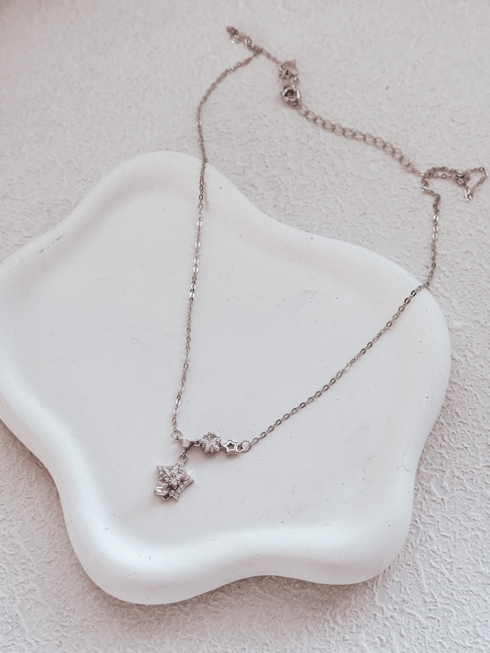 Close-up of Estelle girls necklace on jewellery dish.