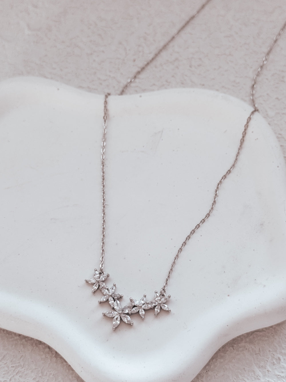 Close-up of Eternal Bloom girls necklace on white background