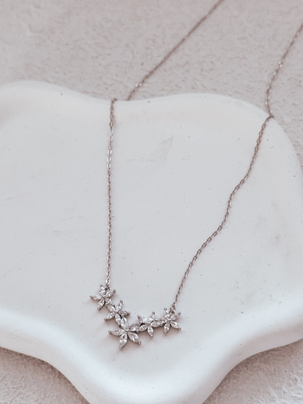 Close-up of Eternal Bloom girls necklace on white background