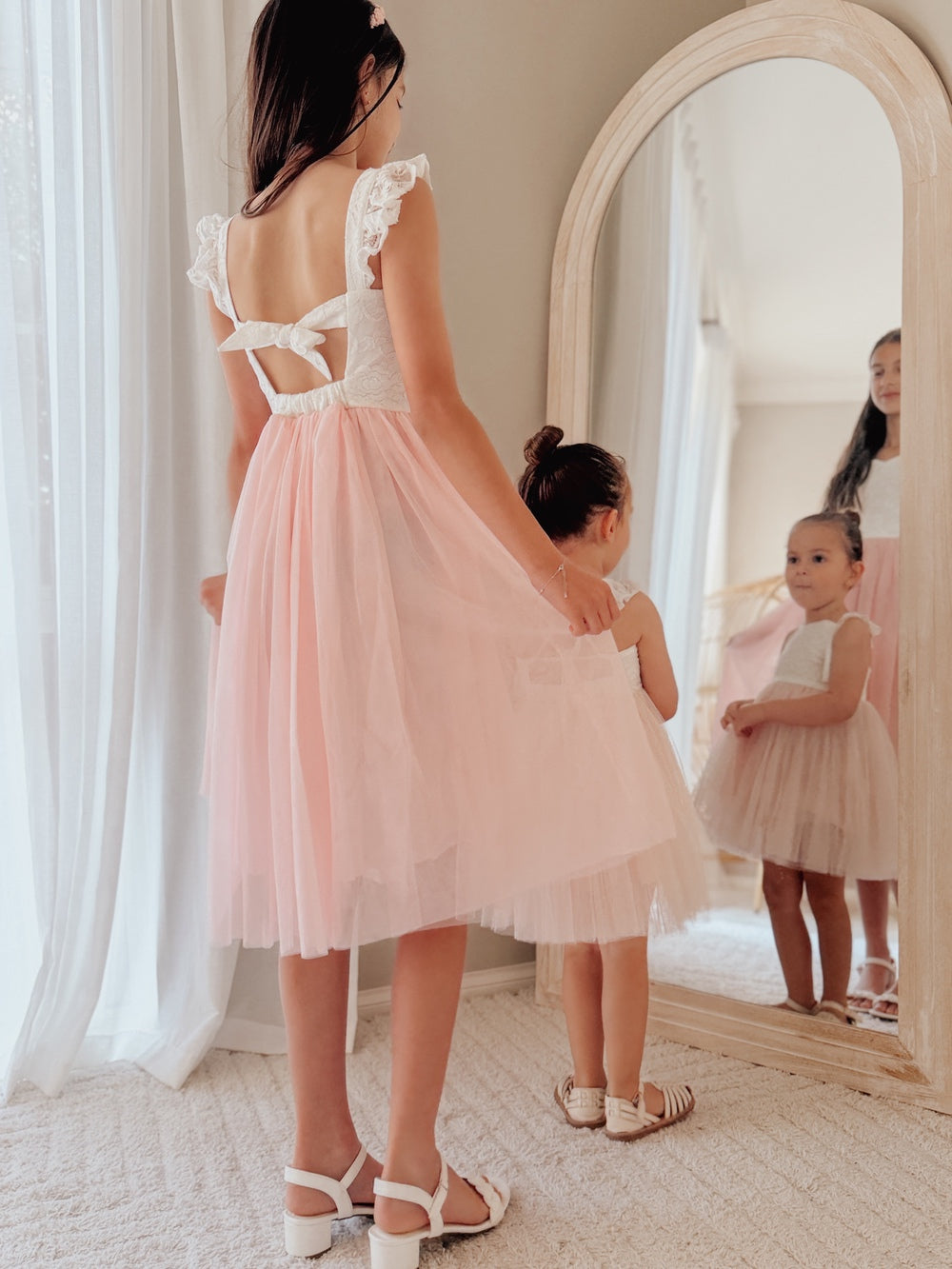 Pink girls occasion dress with ruffle shoulders and tie back