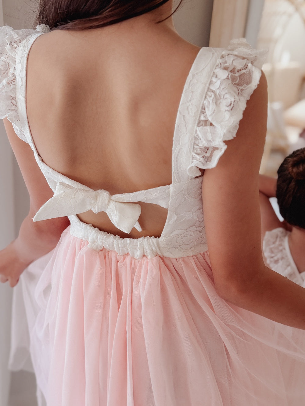 Tie up back straps on soft pink lace girls dress back view