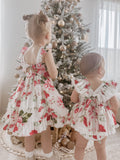 Close-up of Faith Baby Christmas Romper showing white cotton fabric with floral print and broderie anglaise frills