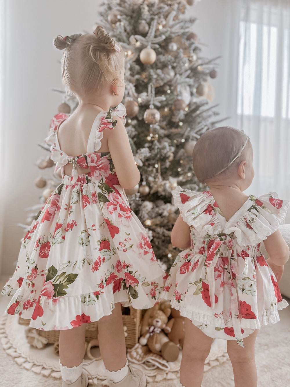 Close-up of Faith Baby Christmas Romper showing white cotton fabric with floral print and broderie anglaise frills