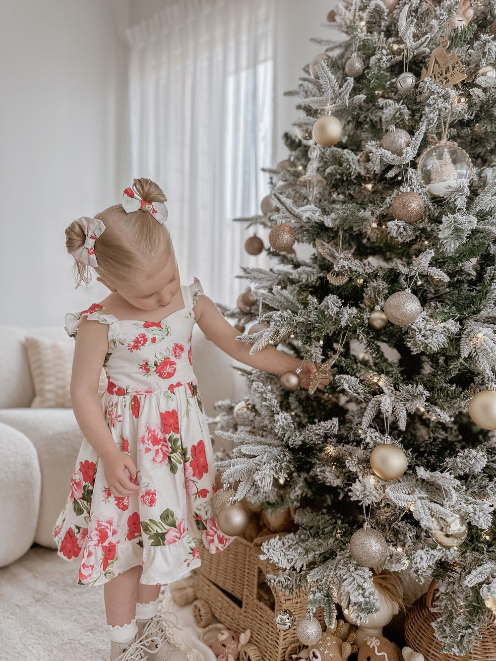 Girl wearing Faith Christmas Rose Dress smiling by the Christmas tree
