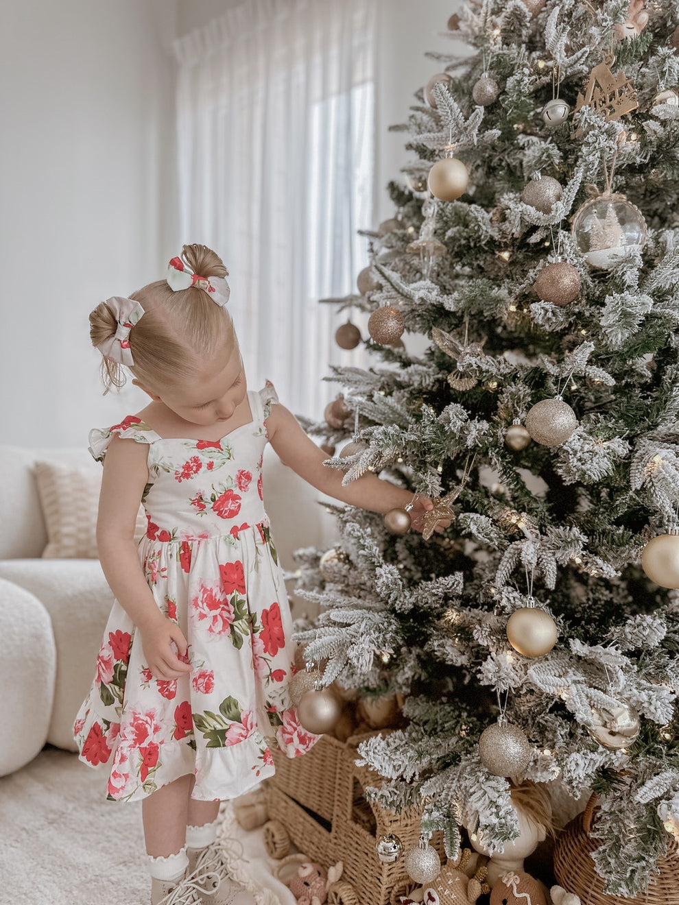 Girl wearing Faith Christmas Rose Dress smiling by the Christmas tree